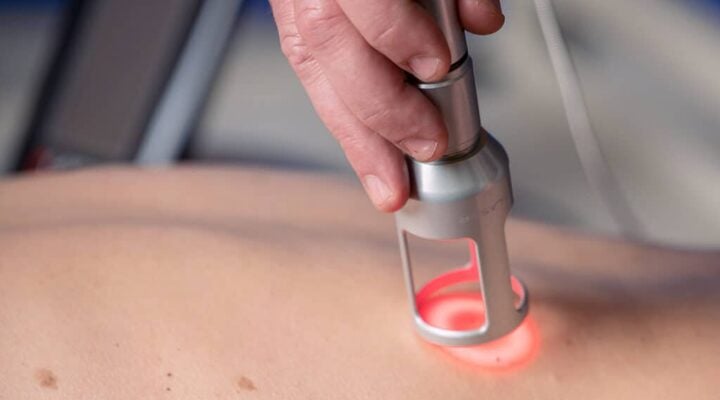 Patient receiving laser therapy treatment to support injury rehabilitation and recovery