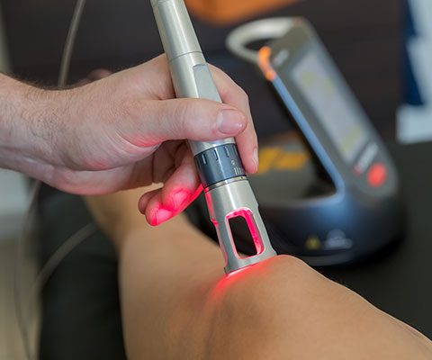 Patient receiving laser pain therapy treatment for arthritis-related joint pain and inflammation